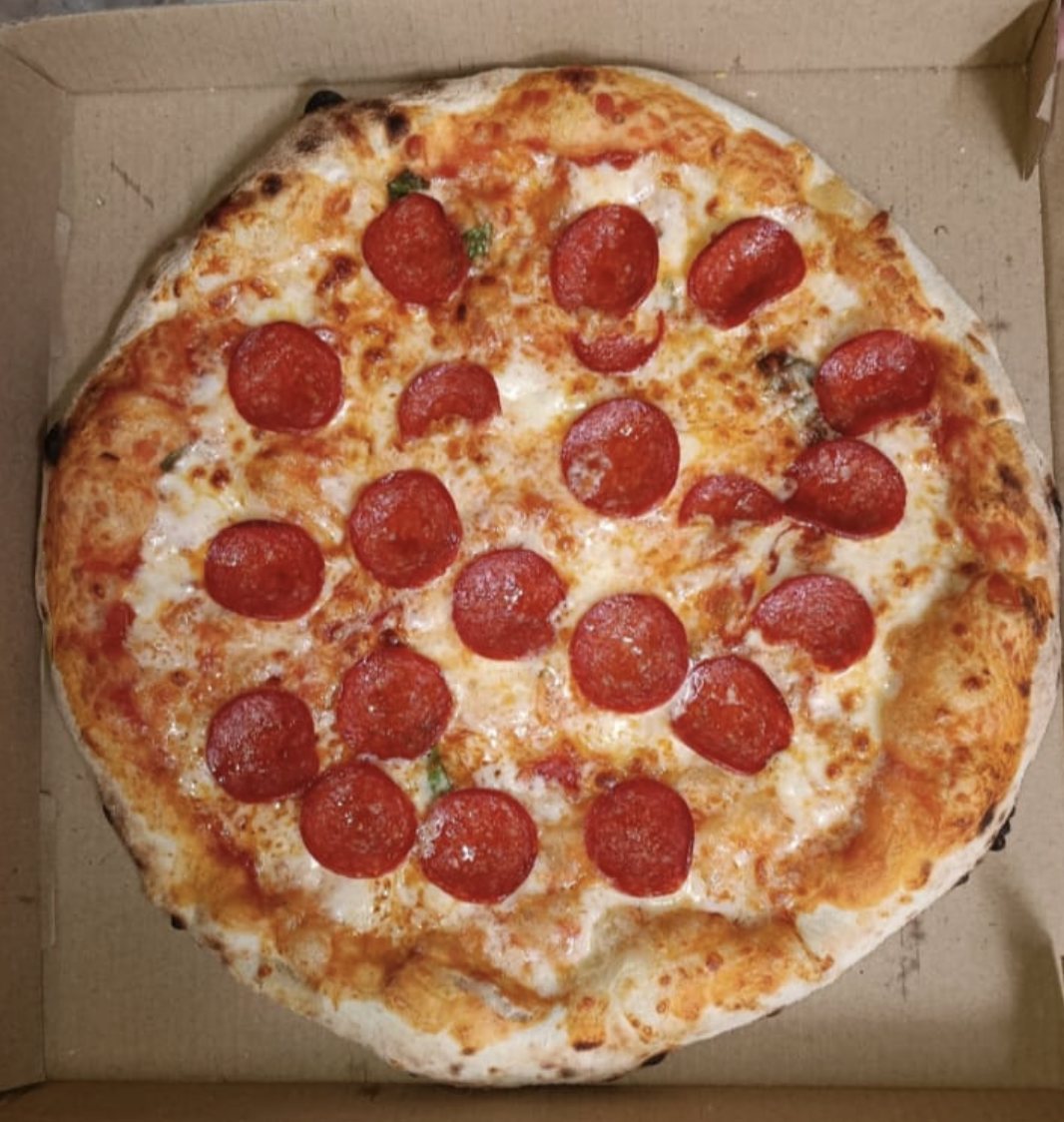 Pizza de peperoni con mozzarella fundida y borde dorado