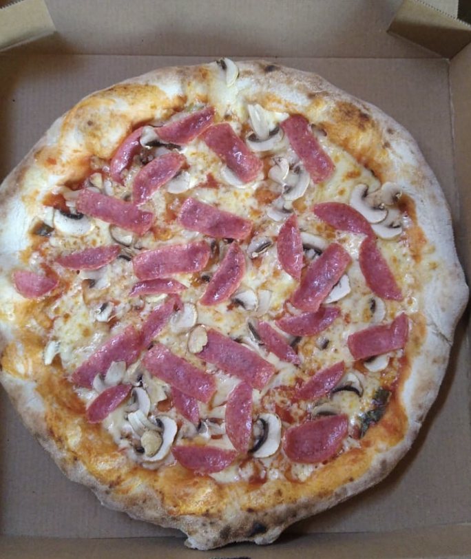 Pizza con longaniza calabresa y champiñones frescos recién salida del horno